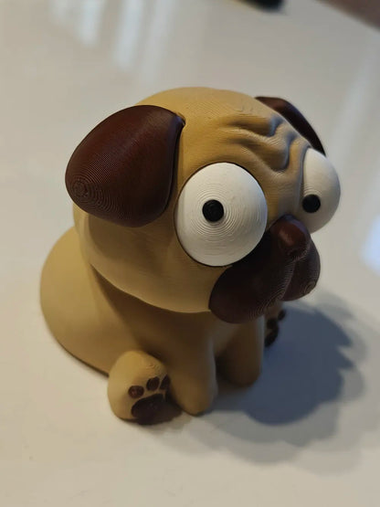 Puggy Mops Goofy Series - vedere din unghi cu un ochi deviat pe masă albă