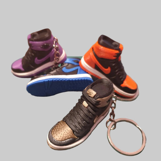 Breloc Mini Sneaker 3D - 3 colorway-uri pe suport de taiere: portocaliu-negru, violet-negru, maro-negru