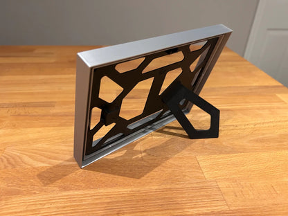 Ramă foto A4 imprimată 3D – vedere orizontală cu suport rabatabil, design geometric negru