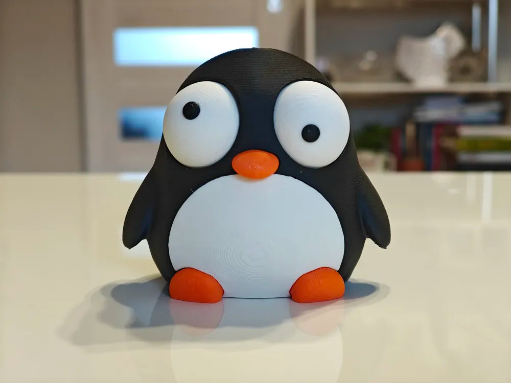 Pinguin Goofy Series - vedere frontală unghi diferit pe masă albă