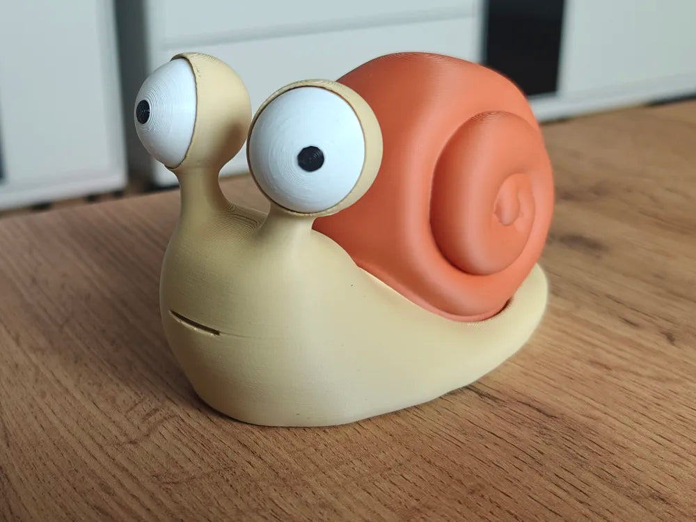 Melc Goofy Series - vedere laterală cu cochilie portocalie pe masă din lemn