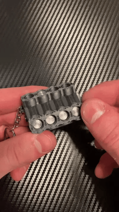 Breloc Motor V8 3D cu Pistoane Mobile - GIF animat pistoane in miscare tinute in mana, fundal carbon