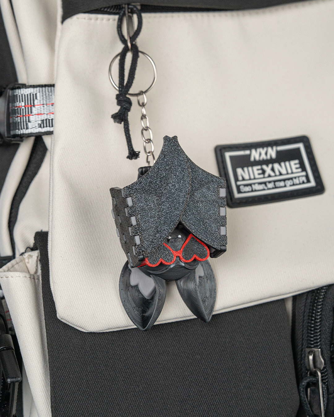 Beach Bat breloc violet agatat pe rucsac alb - aripi pliate cu ochelari inima vizibili, vedere lifestyle