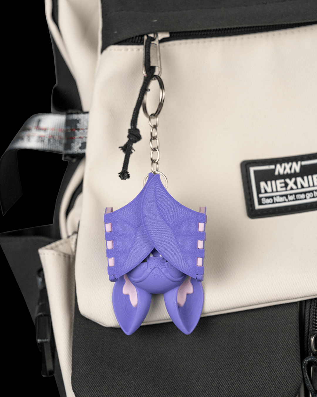 Buff Bat liliac musculos violet vedere spate cu aripi pliabile, inel breloc, fundal negru