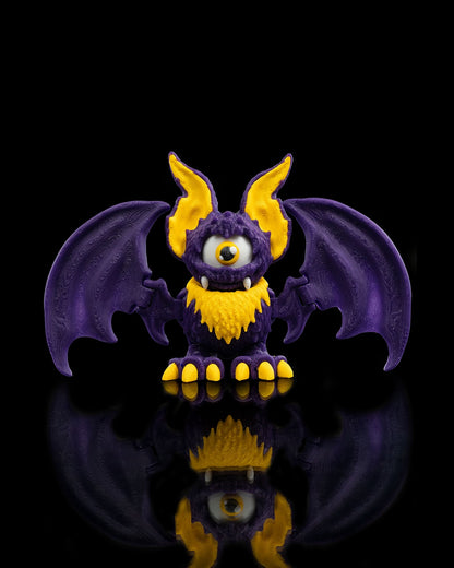 That-looks-bat figurina liliac monstru violet cu ochi galben mare si colti, fundal negru - vedere fata cu aripi intinse