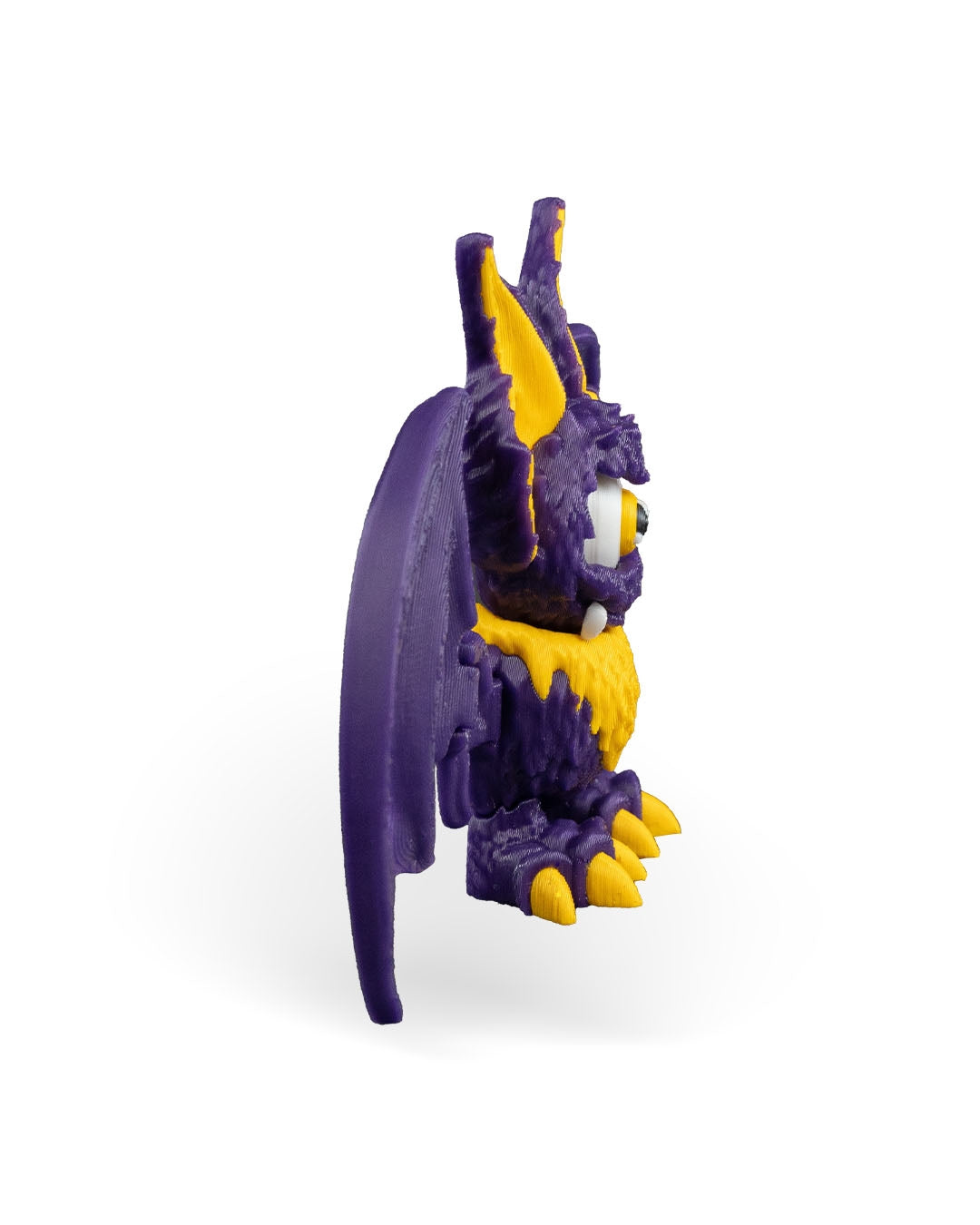 That-looks-bat figurina liliac monstru violet cu blana galbena si colti, vedere 3/4 stanga, fundal alb